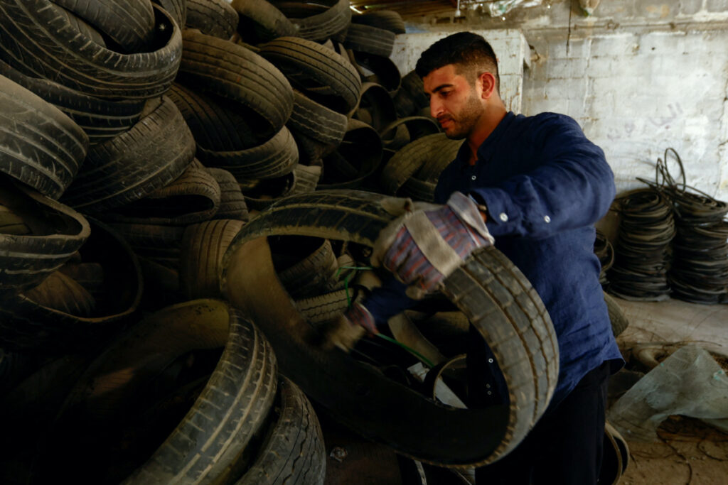 Palestinian Madyan Helles works in his workshop as he turns wasted car tires into environment-friendly materials, in Gaza, on 11th July, 2023.