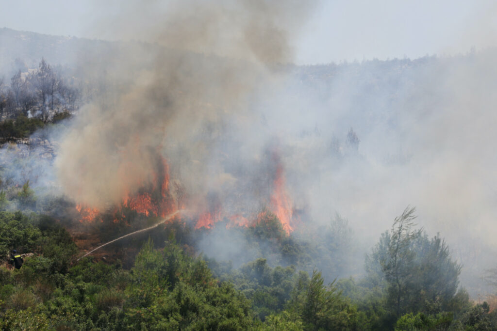 A firefighter tries to extinguish a wildfire burning near the village of Pournari, Greece, on 18th July, 2023