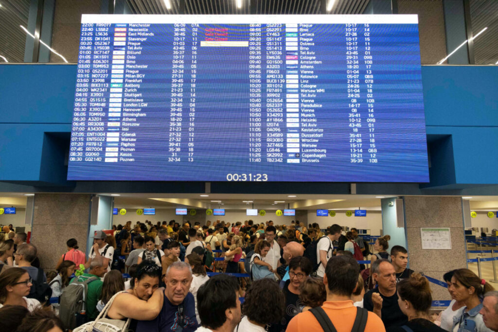 Tourists line up at check-in counters as they wait for departing planes at the airport, after being evacuated following a wildfire on the island of Rhodes, Greece, on 24th July, 2023.
