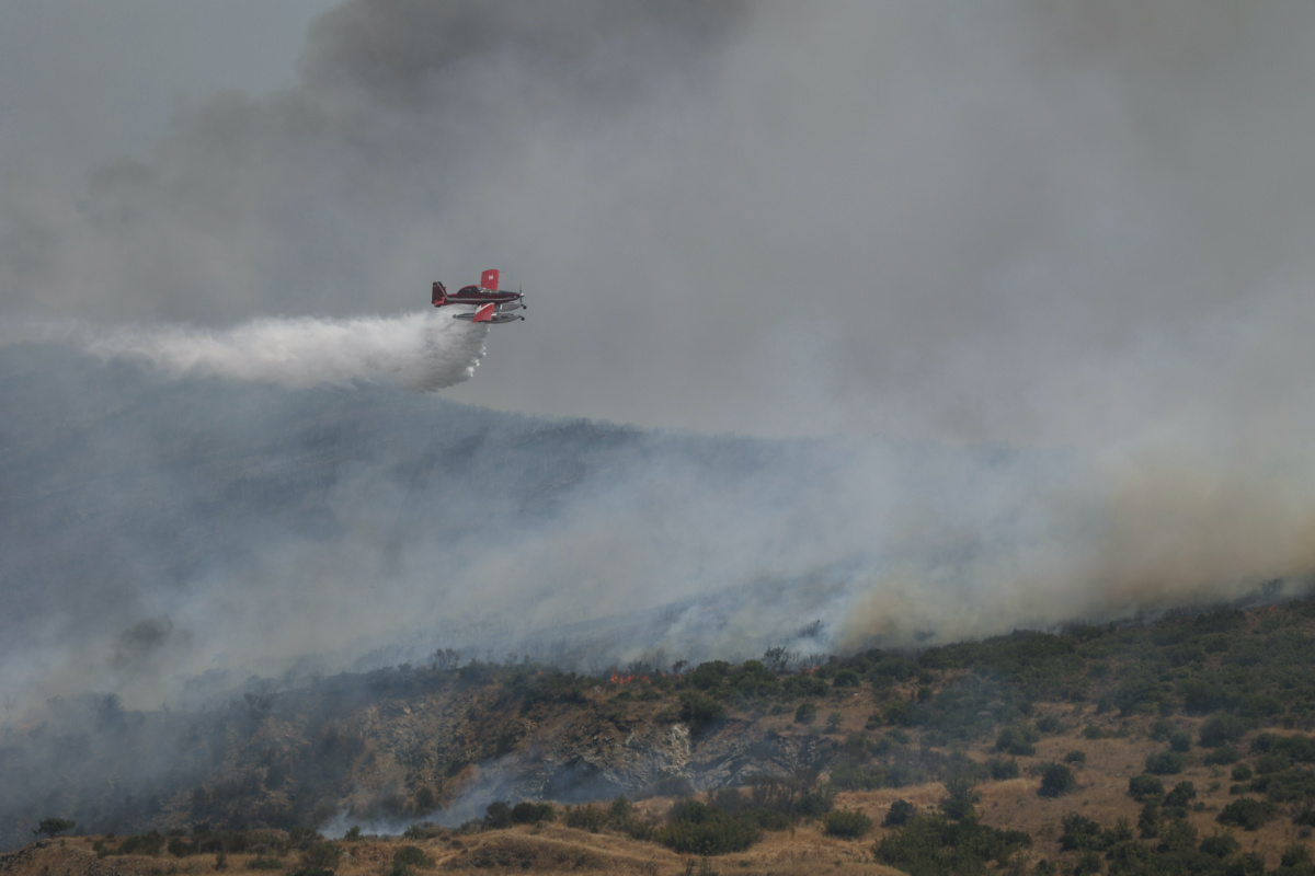 A firefighting plane makes a water drop as a wildfire burns near the city of Volos, in central Greece, on 27th July, 2023. 