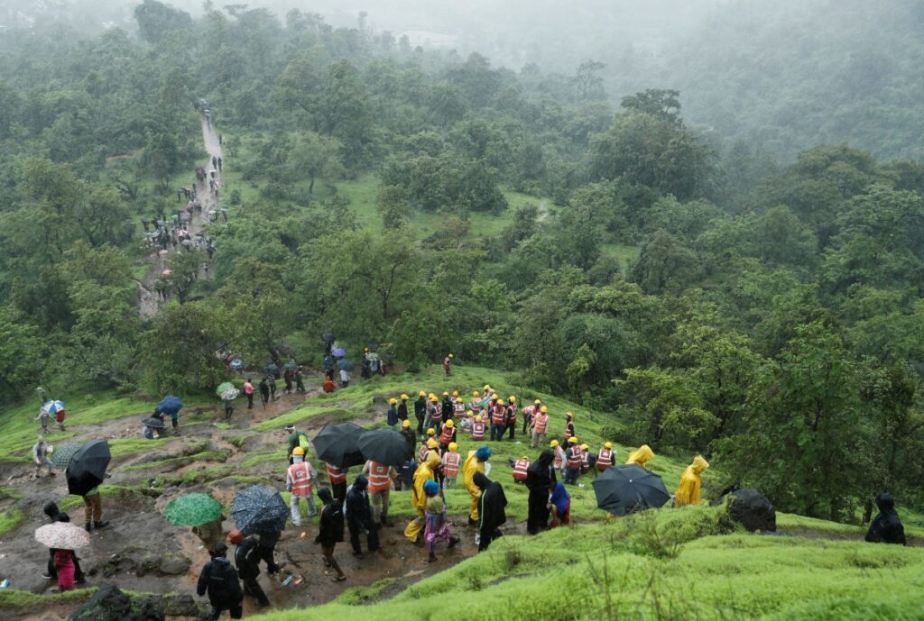 National Disaster Response Force personnel and other volunteers climb up a mountain to reach the site of a landslide at a village in Raigad, in the western state of Maharashtra, India, on 20th July, 2023.