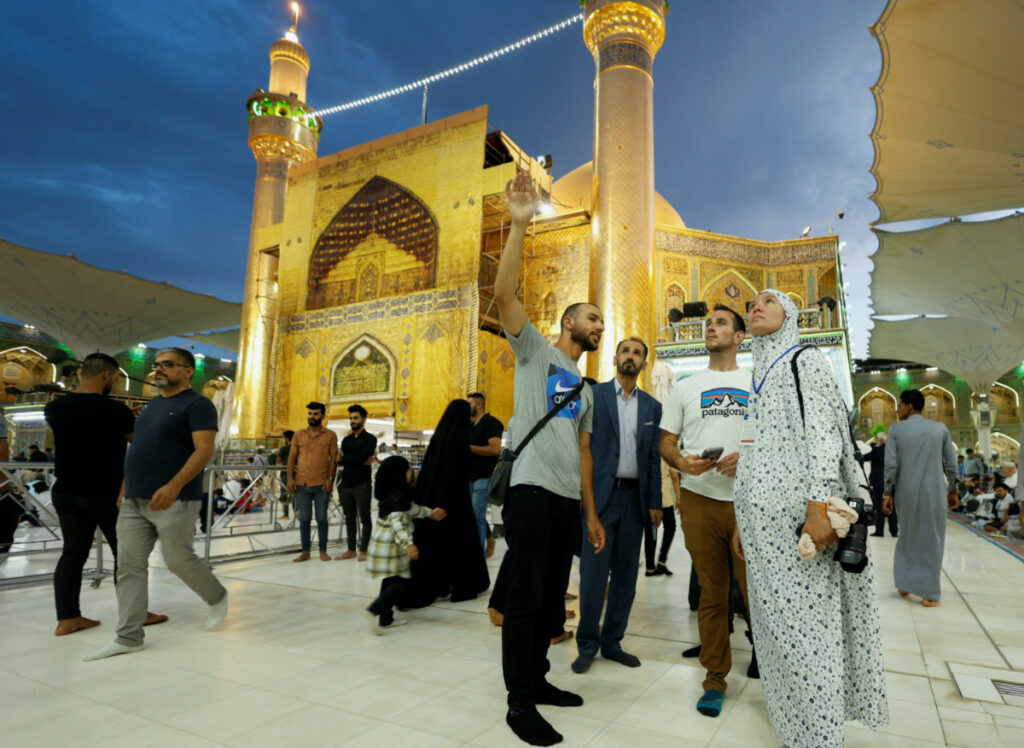 Anna Nikolaevna, 38, a Russian national, and Jacob Nemec, 29, an American national, look on during a tour at Imam Ali shrine, in the holy city of Najaf, Iraq, on 5th June, 2023.