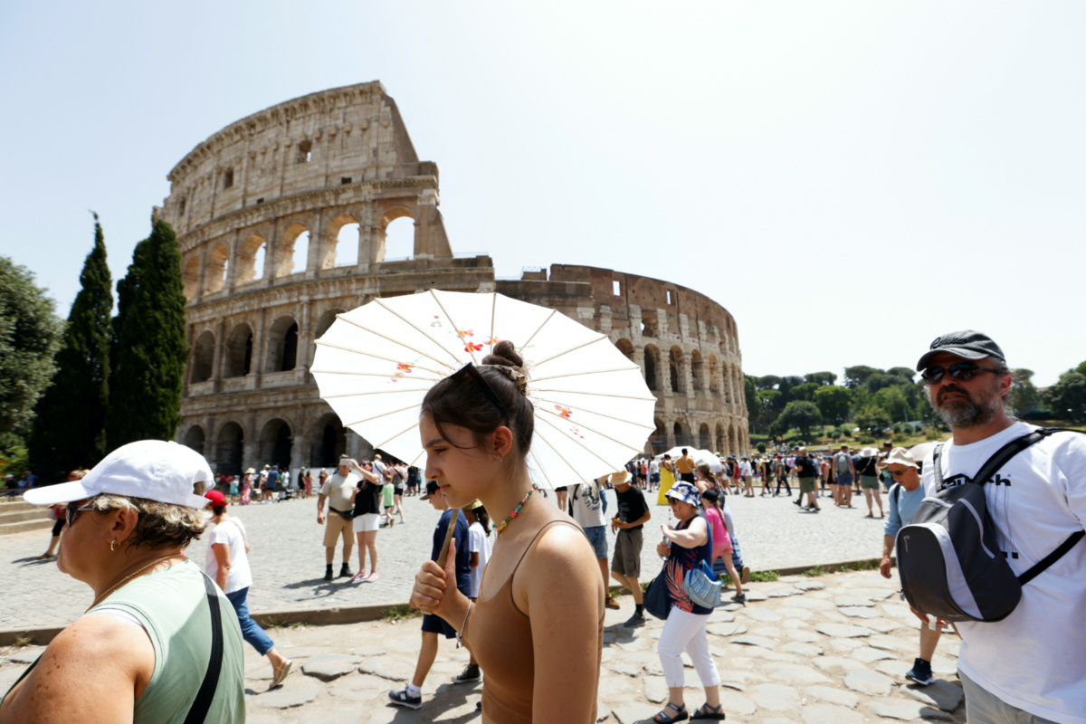 People walk near the Colosseum during a heat wave across Italy as temperatures are expected to rise further in the coming days, in Rome, Italy, on 17th July, 2023.