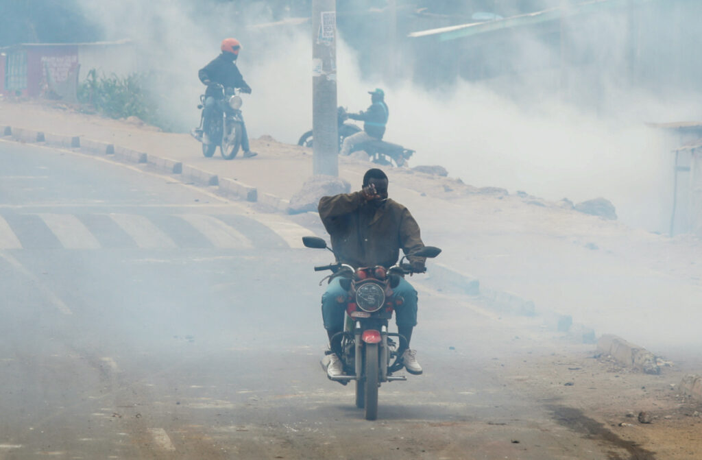 A motorcycle rider reacts as riot police officers lob teargas canisters to disperse supporters of Kenya's opposition leader Raila Odinga of the Azimio La Umoja One Kenya Alliance, as they participate in an anti-government protest against the imposition of tax hikes by the government in Kibera settlement of Nairobi, Kenya, on 12th July, 2023.