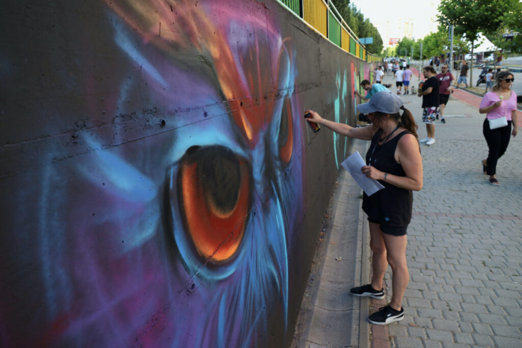 Dizi, a graffiti artist from Greece, paints a mural as part of the Meeting of Styles graffiti festival in Kosovo's capital Pristina, Kosovo, on 28th July, 2023.