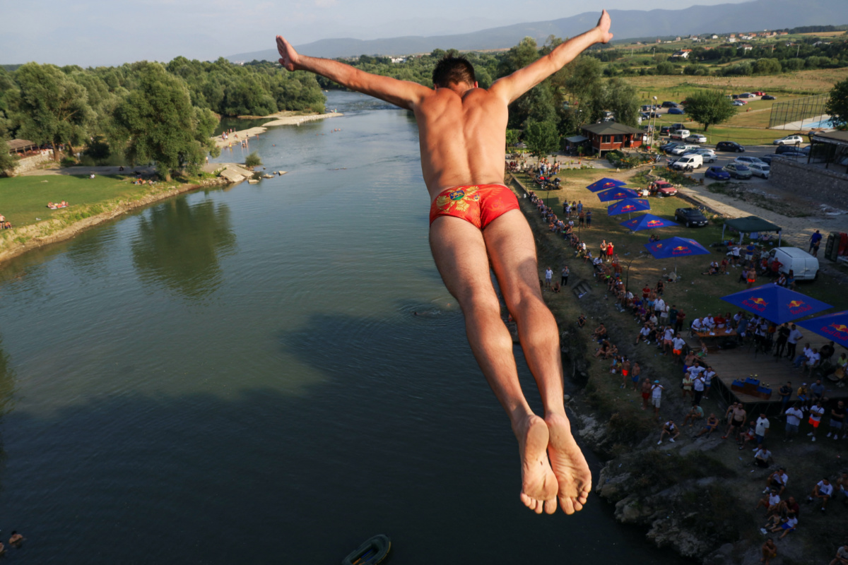 Evald Krnic, a diver from Montenegro, jumps from a bridge during a competition on the White Drin River, near the town of Gjakova, Kosovo, on 23rd July 2023