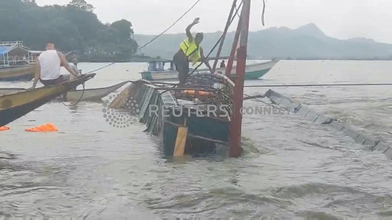 A man stands on the capsized passenger boat in Binangonan, Rizal province, Philippines, on 27th July, 2023 in this screen grab taken from a video by Philippine Coast Guard