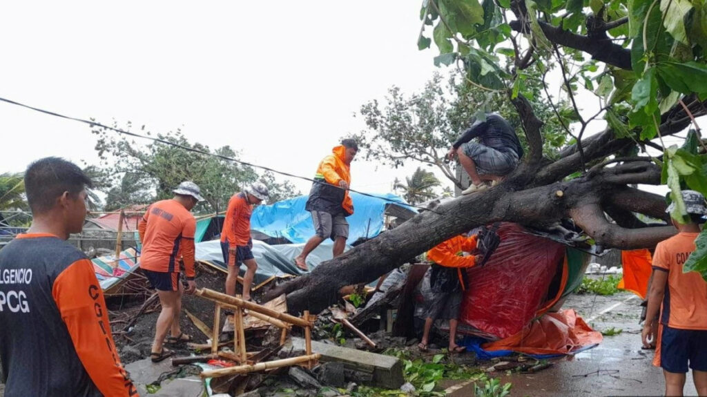 Members of the Philippine Coast Guard remove a fallen tree from a road following the onslaught of Typhoon Doksuri in Buguey, Cagayan province, Philippines, on 26th July, 2023.