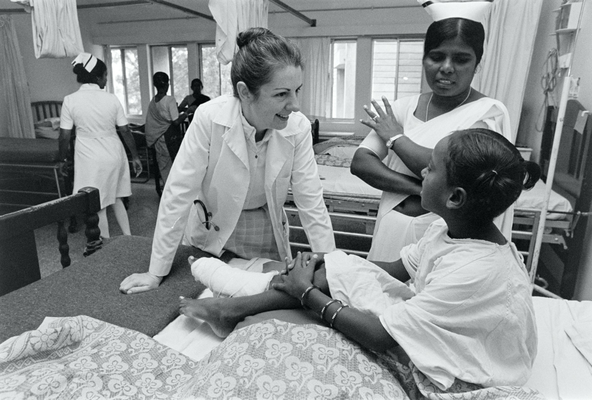 Dr Rebekah Naylor talks with a young patient alongside a national nurse at Bangalore Baptist Hospital in Bangalore, India, in 1986