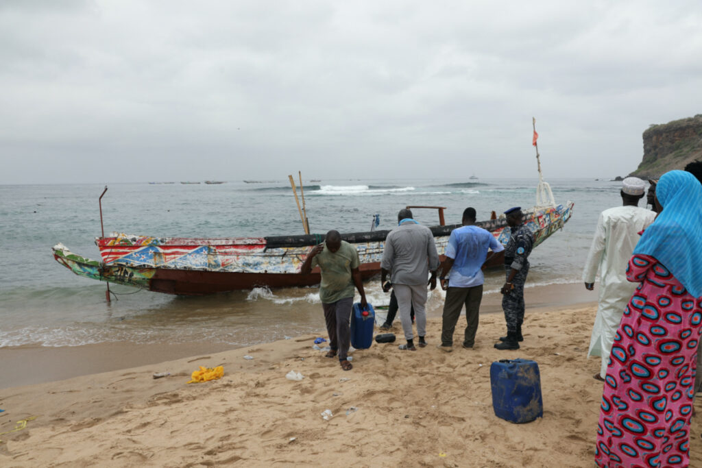 Locals remove fuel containers from the boat that ran aground off the coast of Ouakam, carrying migrants who attempted irregular immigration, Dakar, Senegal, on 24th July, 2023.