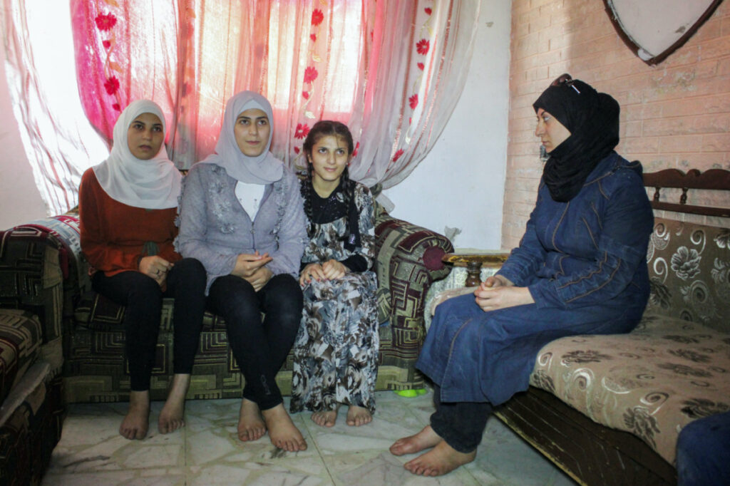 Nesma Daher sits with her children inside a room in Douma, Syria, on 19th June, 2023.