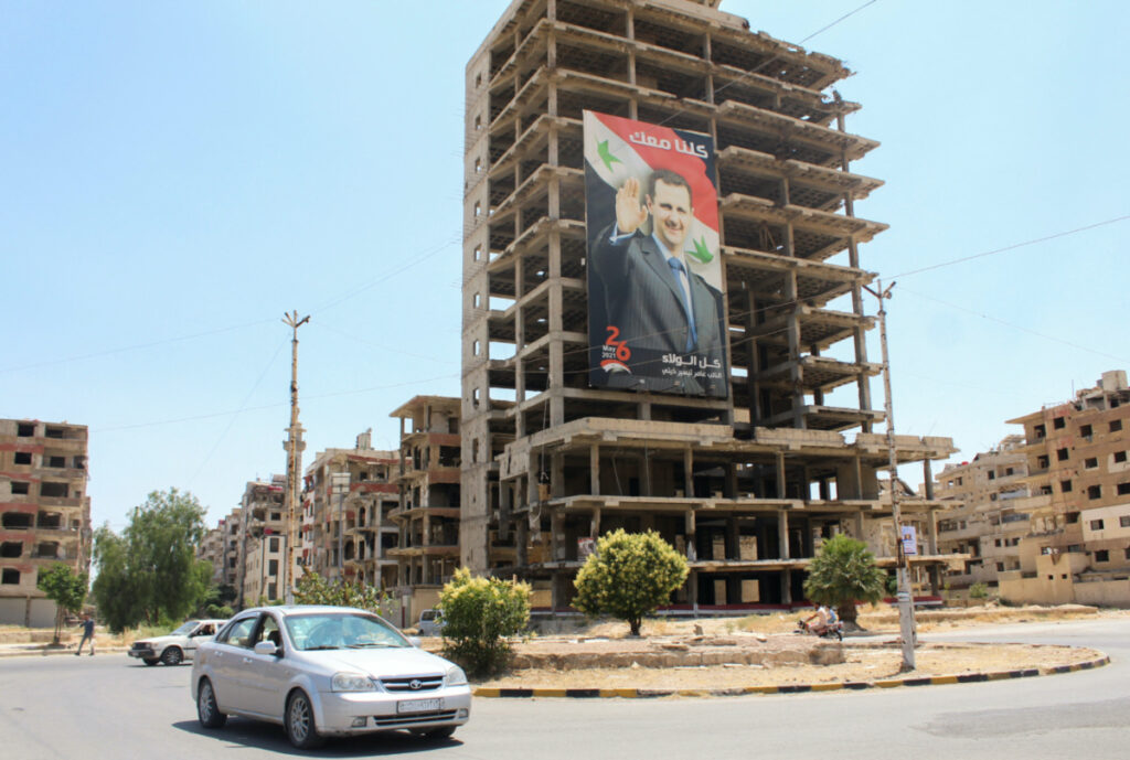 Vehicles pass near a poster depicting Syria's President Bashar al-Assad in Douma, Syria, on 19th June, 2023.