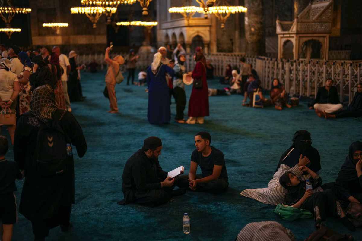 Muslim worshippers, center, read the Quran, Muslim's holiest book, as tourists and locals visit Byzantine-era Hagia Sophia mosque in Istanbul, Turkey, on Tuesday, 4th July, 2023.