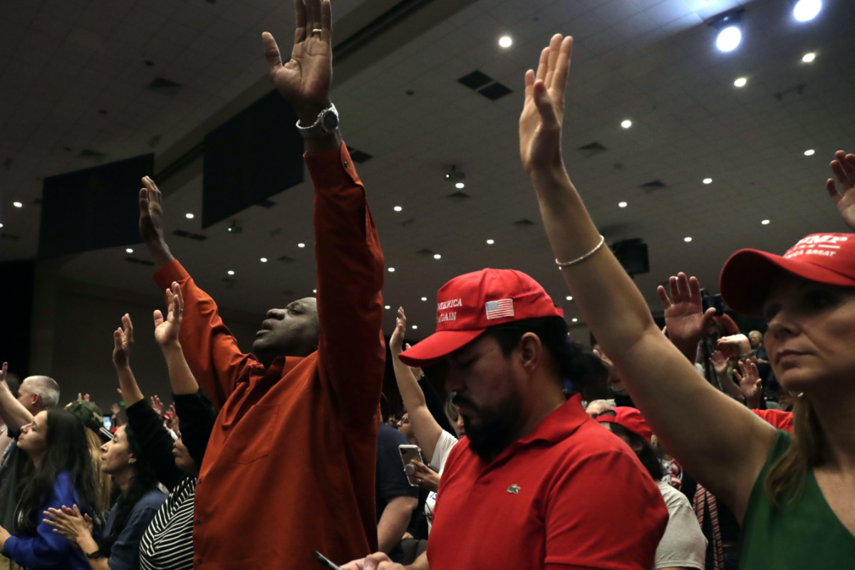 People raise their arms in prayer during a rally for evangelical supporters of President Donald Trump at the King Jesus International Ministry church, on Friday, 3rd January, 2020, in Miami.