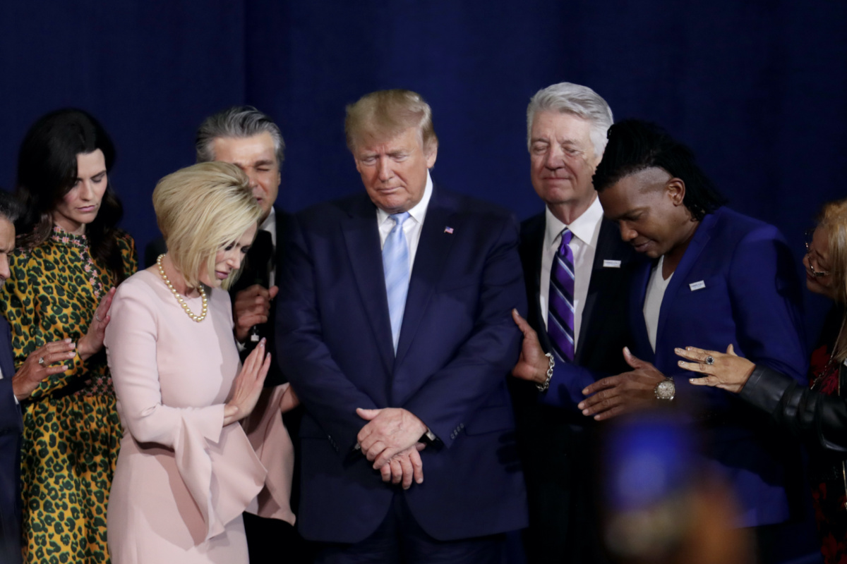 Pastor Paula White, left, and other faith leaders pray with President Donald Trump, centre, during a rally for evangelical supporters at the King Jesus International Ministry church, on Friday, 3rd January, 2020, in Miami.