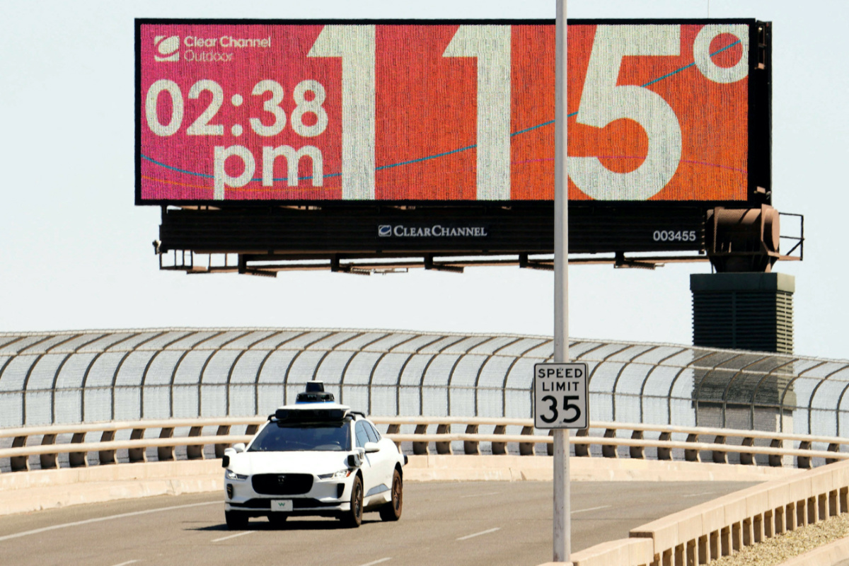 A Waymo self-driving car drives on Seventh Street as the temperature of 115 degrees is displayed on a digital billboard in downtown Phoenix, Arizona, US, on 17th July, 2023. 