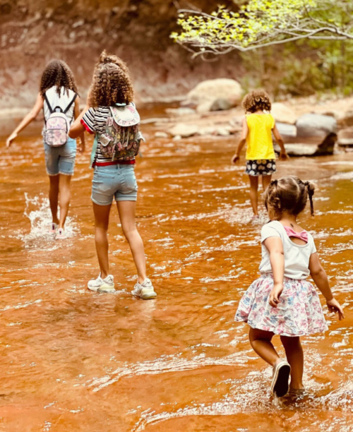 Brytni McNeil's four children hike through a shallow stream.