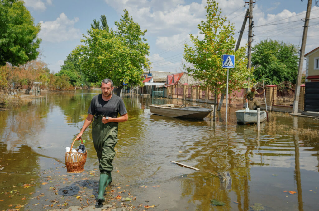 Men commute along a street after floodwaters receded following the collapse of the Nova Kakhovka dam in the course of Russia-Ukraine conflict, in the town of Hola Prystan in the Kherson region, Russian-controlled Ukraine, on 6th July, 2023