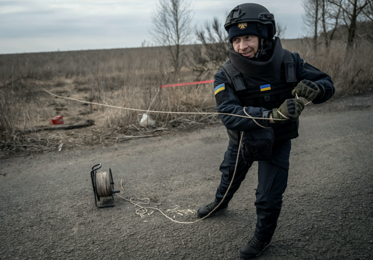 A sapper of the State Emergency Service pulls an anti-tank mine as he inspects an area for mines and unexploded shells, amid Russia's attack on Ukraine, in Kharkiv region, Ukraine, on 21st March, 2023