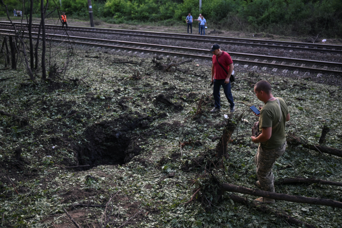 Local residents inspect a crater left after a Russian missile strike, amid Russia's attack on Ukraine, in Zaporizhzhia, Ukraine, on 29th July, 2023.