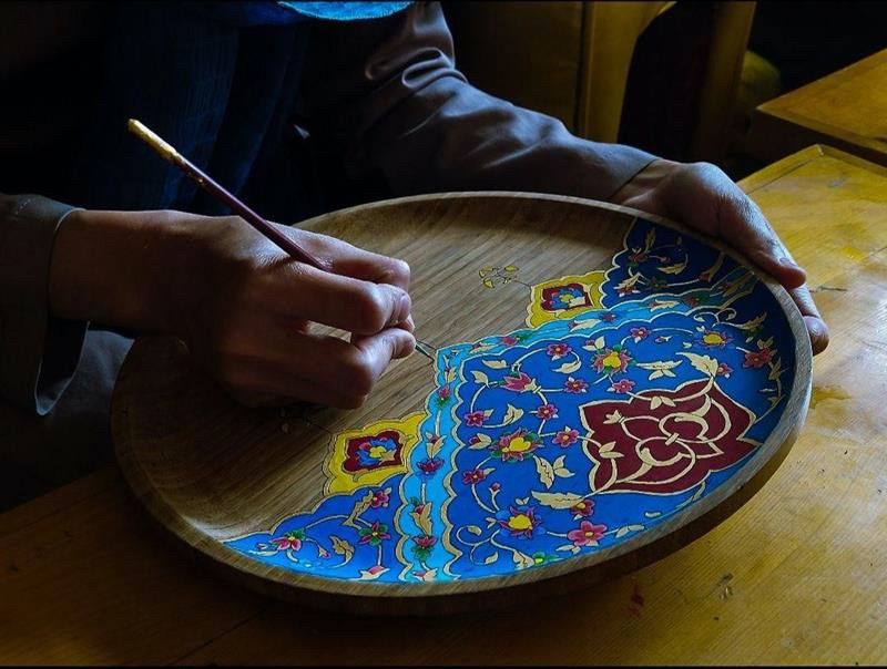 An Afghan woman paints a tray at a handicraft centre in Kabul run by Laila Haidari.