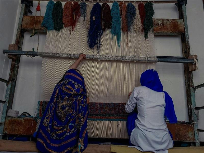 Afghan women weave a rug at a handicraft centre in Kabul run by Laila Haidari. 