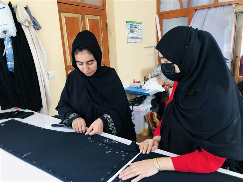 Tailor Wajiha Sekhawat works on a pattern at her home studio in Herat. 