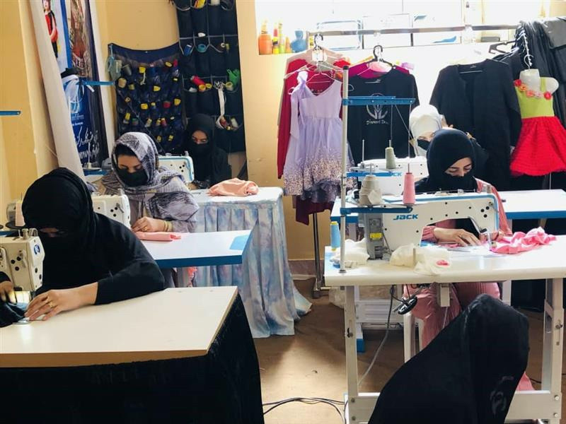 Afghan women work at Wajiha Sekhawat's tailoring studio in Herat. 