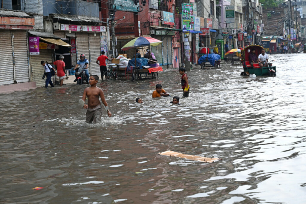 Vehicles try to driving through the waterlogged streets after a heavy downpour in Dhaka, Bangladesh, on 12th June, 2023