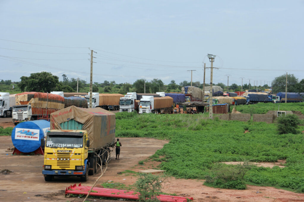 Trucks carrying food, humanitarian aid, and industrial equipment wait due to sanctions imposed by Niger's regional and international allies, in the border town of Malanville, Benin, on 18th August, 2023