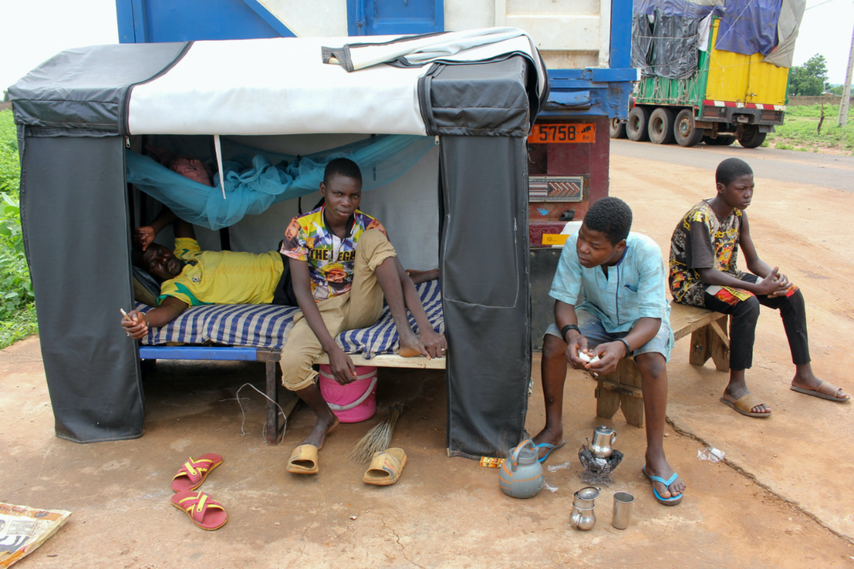 Truck drivers rest as trucks carrying food, humanitarian aid and industrial equipment wait due to sanctions imposed by Niger's regional and international allies, in the border town of Malanville, Benin, on 18th August, 2023