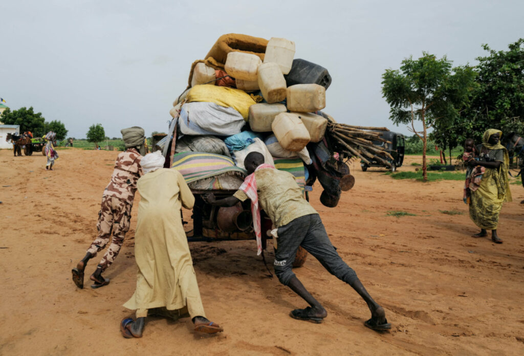 A Chadian cart owner who transports belongings of Sudanese people who fled the conflict in Sudan's Darfur region, pushes his cart while crossing the border between Sudan and Chad in Adre, Chad, on 4th August, 2023.