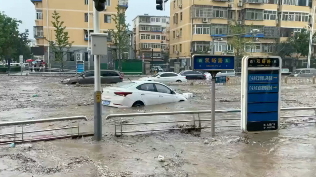Cars are partially submerged as water gushes on a flooded street, after Typhoon Doksuri made landfall and brought heavy rainfall, at the Mentougou district, in Beijing, China, on 31st July, 2023, in this still image obtained from social media video.