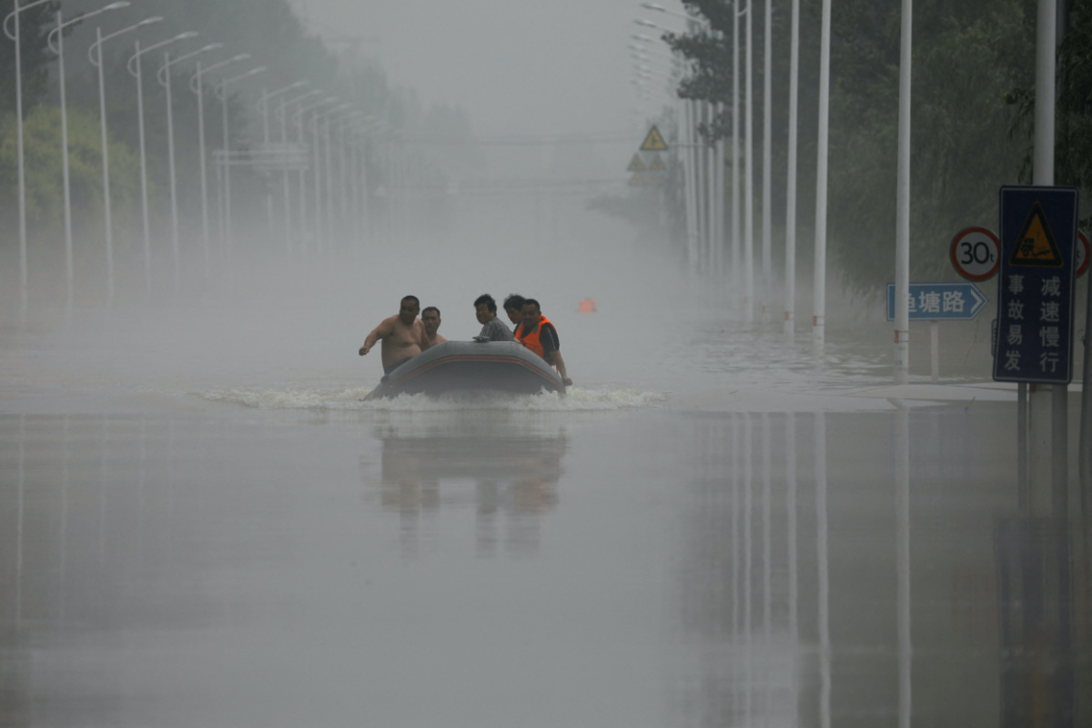People ride a boat through a flooded road after the rains and floods brought by remnants of Typhoon Doksuri, in Zhuozhou, Hebei province, China, on 3rd August, 2023. 