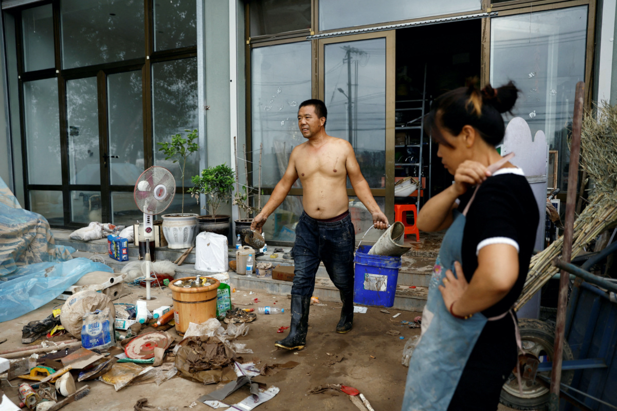 Li Yujie, 47, looks on as Zhang Hongwei, 48, sorts muddied items at their flood-stricken hardware store after the rains and floods brought by remnants of Typhoon Doksuri, in Zhuozhou, Hebei province, China, on 7th August, 2023. 