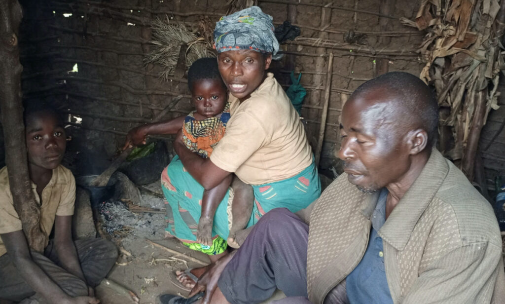 Nsimire Nankafu, an Indigenous pygmy woman, and her family sit inside their shelter after a consultation meeting with the indigenous peoples of the Muyange village in Tshivanga near the Kahuzi-Biega National Park, in the South Kivu Province of the Democratic Republic of the Congo, on 16th June, 2023.