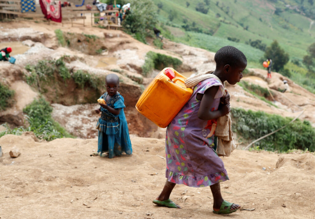 A girl carries a container of water at a coltan mine in Kamatare, Masisi territory, North Kivu Province of Democratic Republic of Congo, on 1st December, 2018