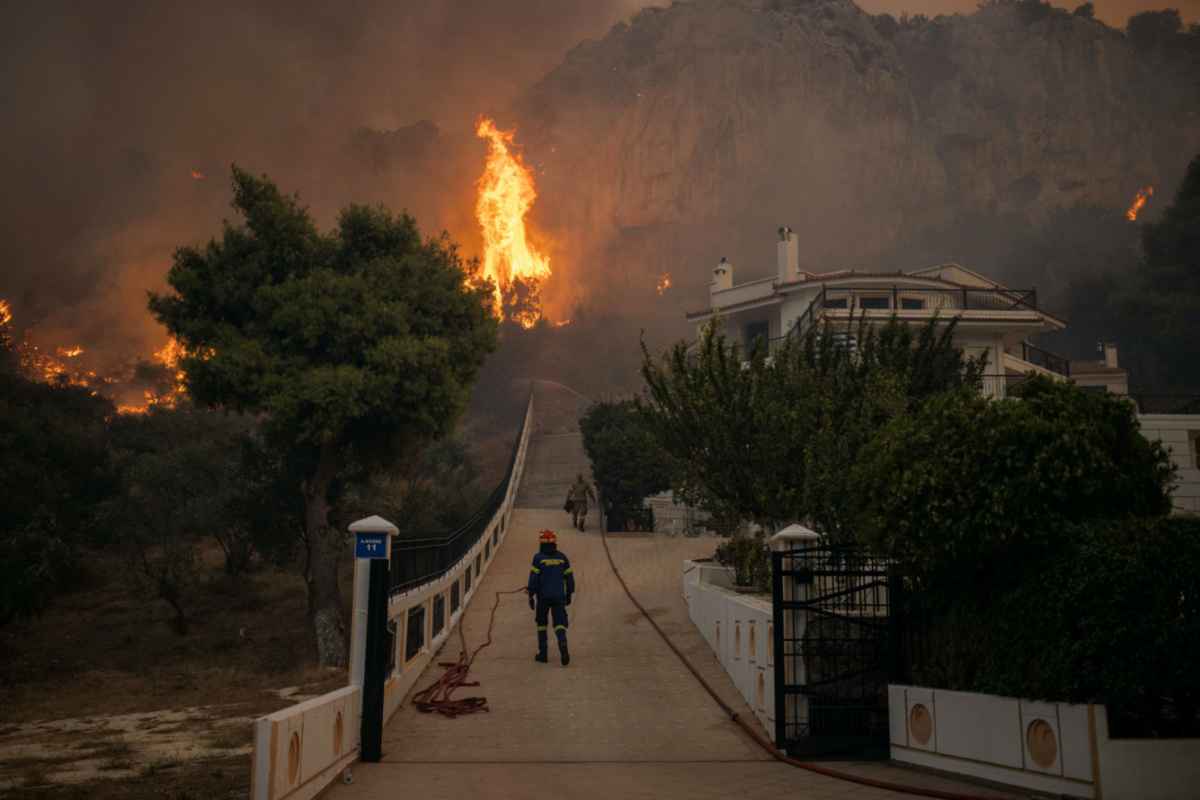 Firefighters and volunteers try to tackle a wildfire burning in the village of Hasia, near Athens, Greece, on 22nd August, 2023