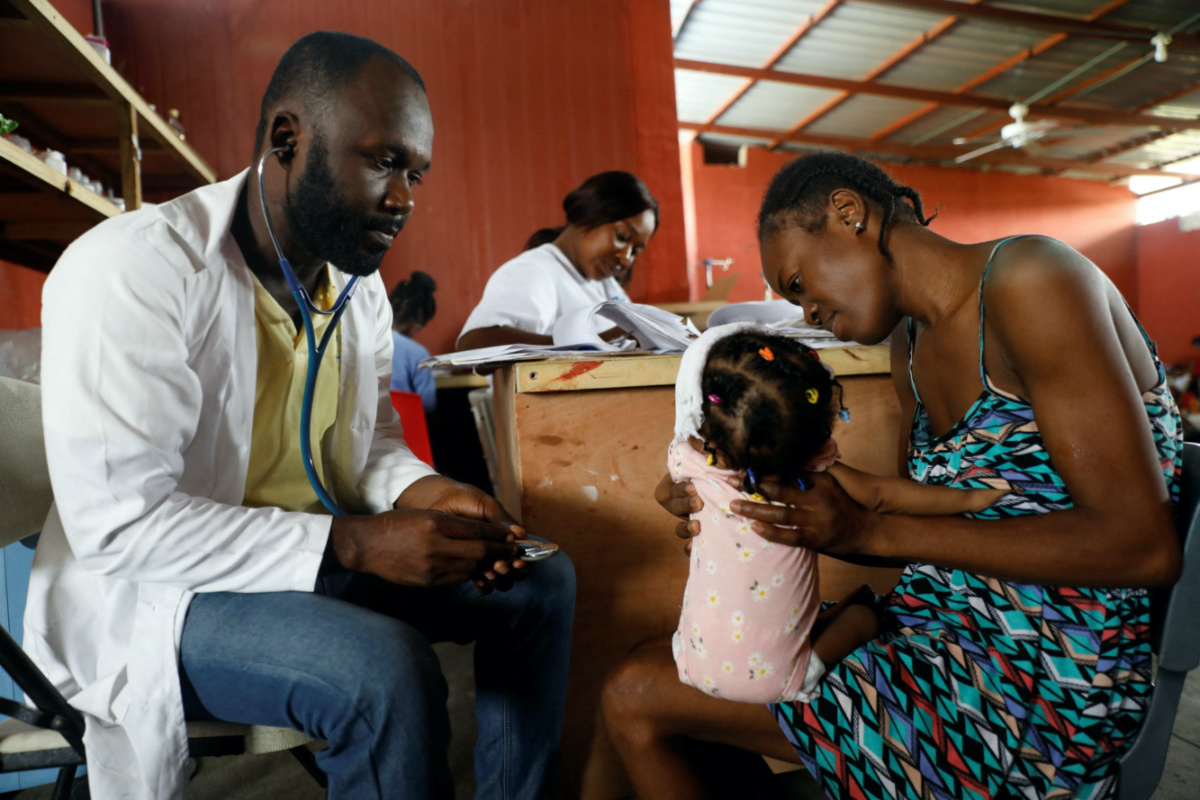 Mackenson Pierre, a doctor, treats Marie Michelle Joseph's nine-month-old baby Myleisha Moliere at the Centre Hospitalier de Fontaine, located in the impoverished neighbourhood of Cite Soleil, where the two rival gangs, G-Pep and G-9, are based, in Port-au-Prince, Haiti, on 27th July 2023.