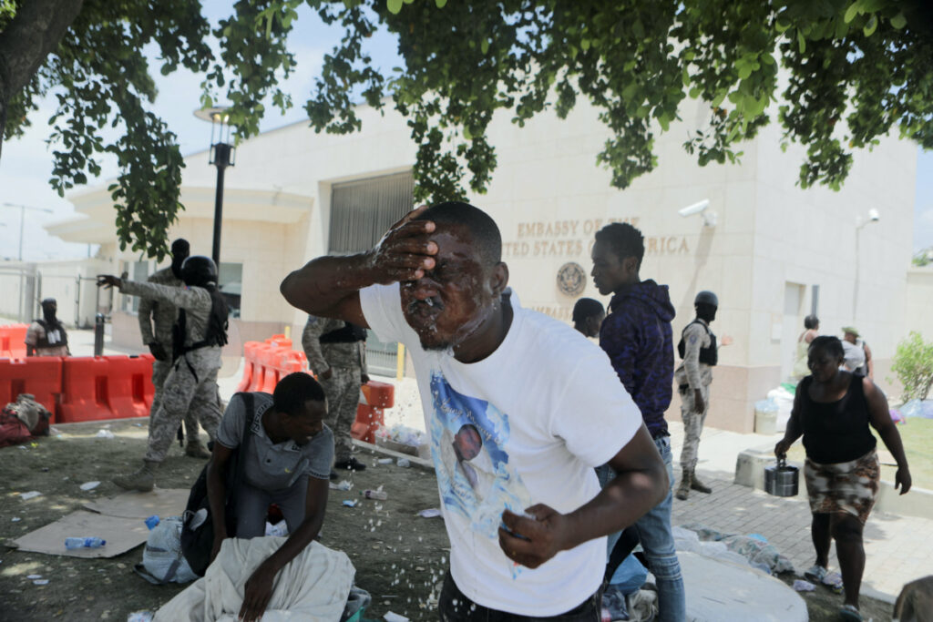 A man washes his face after officers of the Haitian National Police fired tear gas to clear a camp of people escaping the threat of armed gangs, in front of the US Embassy, in Port-au-Prince, Haiti, on 25th July, 2023.