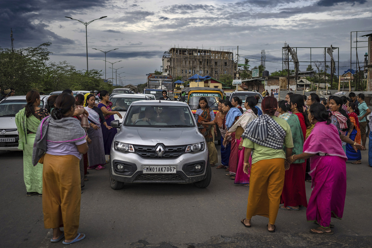 Members of Meira Paibis, a powerful vigilante group of Hindu majority Meitei women, block traffic as they check vehicles for the presence of members from the rival Christian tribal Kuki community, in Imphal, capital of the northeastern Indian state of Manipur, on 19th June, 2023. 