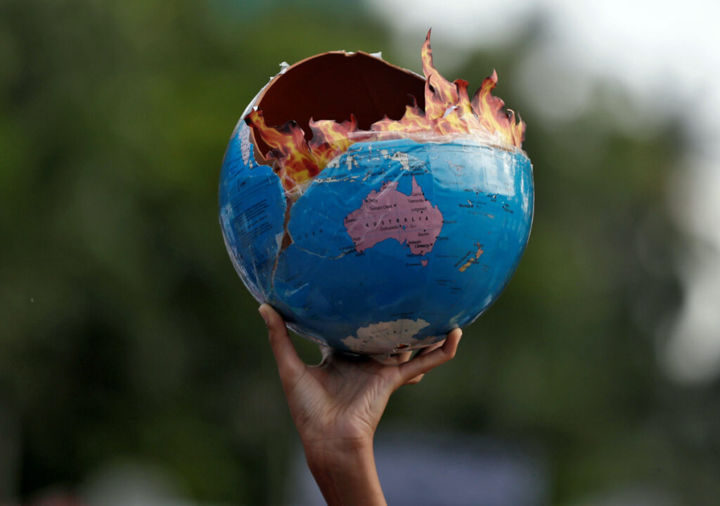 A participant holds a replica depicting globe on fire during a "Fridays for Future" march calling for urgent measures to combat climate change, in Mumbai, India, on 27th September, 2019
