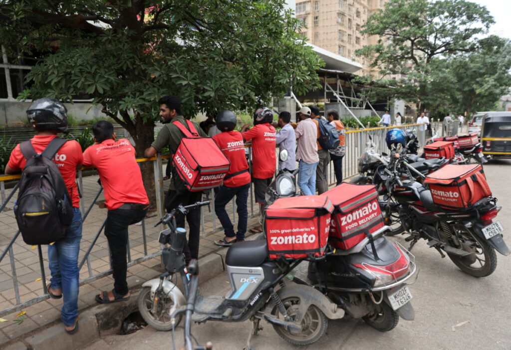 Gig workers wait in line to collect their delivery order outside a mall in Mumbai, India, on 10th August, 2023.