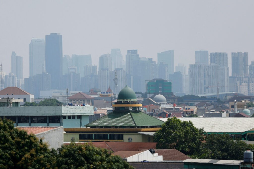 Mosques are seen in a residential area, as smog covers high-rise buildings in the background, in Jakarta, Indonesia, on 9th August, 2023.