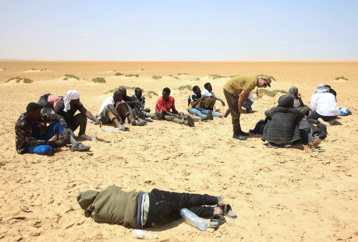 Migrants from Africa rest while they are stranded in the desert on the Libyan-Tunisian border near Al-Assah, Libya, on 5th August, 2023.