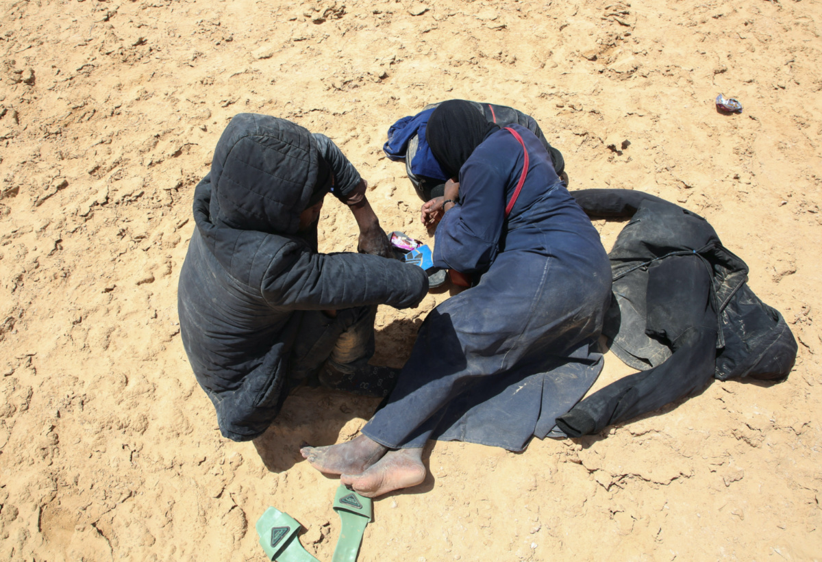 Blessing David, a pregnant 20-year-old woman from Ghana, and her husband rest while they are stranded in the desert on the Libyan-Tunisian border, near Al-Assah, Libya, on 5th August, 2023.