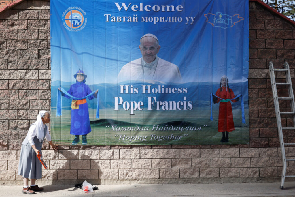 A nun installs a poster with an image of Pope Francis outside the bishop’s house, where he is expected to stay during his Apostolic Journey, one day ahead of his arrival in Ulaanbaatar, Mongolia, on 31st August, 2023
