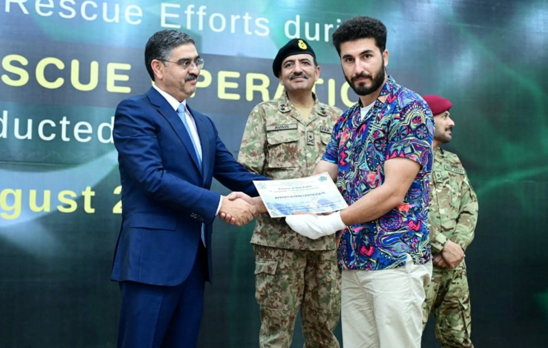 Pakistan's caretaker Prime Minister Anwaar-ul-Haq Kakar awards appreciation certificate to rescuer Mohammad Ali, zipline rescuer of Battagram chairlift incident, during a ceremony at Prime Minister House in Islamabad, Pakistan, on 24th August, 2023. 