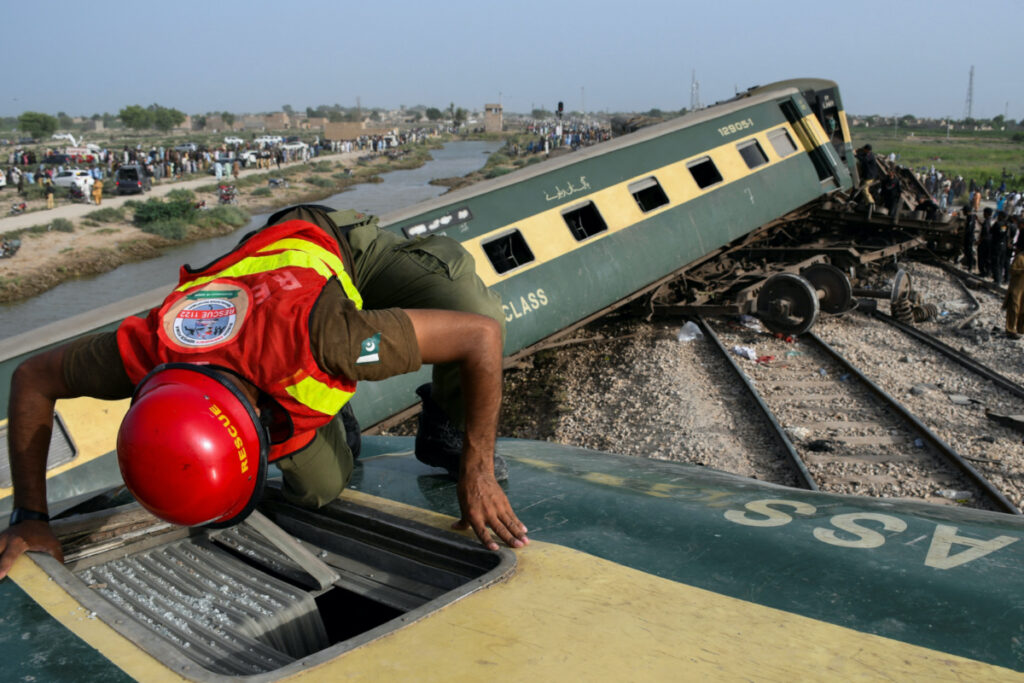 A rescue worker searches for victims after a train derailed in Sarhari town in district Sanghar, Pakistan, on 6th August, 2023.