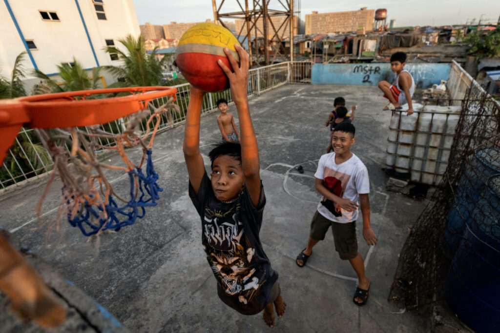 Children play basketball on the rooftop of tenement housing in Tondo, Manila, Philippines, on 17th May, 2023